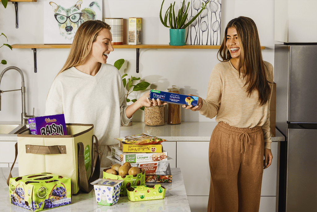 Deux femmes chargeant des courses du comptoir au réfrigérateur